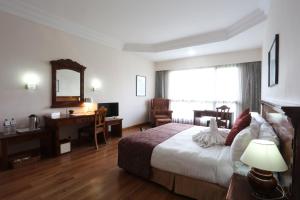 A bed or beds in a room at Hotel Pokhara Grande