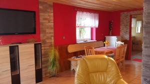un soggiorno con pareti rosse, TV e tavolo di Liptovská Chata pri potoku a Liptovský Mikuláš