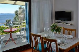 a dining room with a table and a view of the ocean at Apartments Miki in Donja Klada