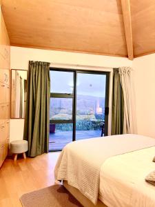 a bedroom with a bed and a large window at Ridge Valley View in Whenuakite +23 photos