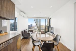 a kitchen and living room with a table and chairs at Realm Apartments by CLLIX in Adelaide