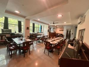 a dining room with wooden tables and chairs at Hotel Rongla in Pālampur