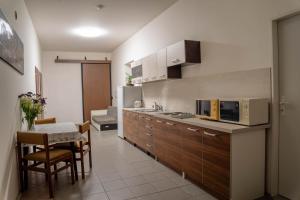 a kitchen with a sink and a table and a microwave at Penzion u Karla in Jamolice