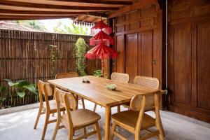 a wooden table and chairs on a patio at Dapur Alit Villas in Yogyakarta