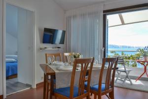 a dining room with a table and chairs and a balcony at Apartments Miki in Donja Klada