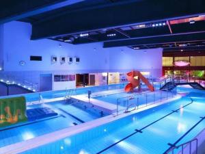 a large indoor swimming pool with a large swimming pool at Riverside Cottage Äänekoski Sauna Hot Tub Northern Lights in Äänekoski