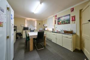 a kitchen with a table and a table and chairs at Squatters Cottage in Port Augusta