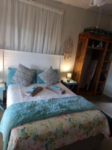 a bedroom with a large bed with pillows on it at Geckos Rest Southbroom in Southbroom