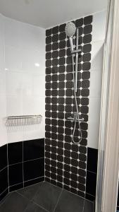 a shower in a bathroom with black and white tiles at The Bala's Holiday Chalet in Cameron Highlands +60 photos
