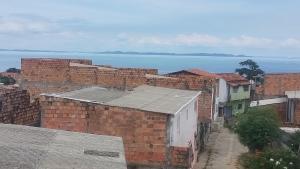 a group of brick buildings with the ocean in the background at 3-bedroom house on Cabuçu beach in Saubara