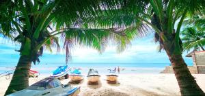 a group of boats on a beach with palm trees at Matie Beach Hotel & Resort in Kao Kuil