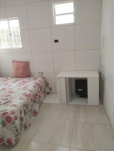 a white room with a bed and a table at 3-bedroom house on Cabuçu beach in Saubara