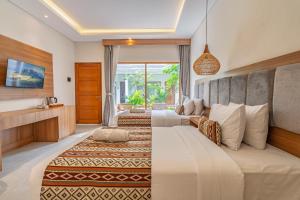 a hotel room with two beds and a television at Casa Wina Kuta by The Wina Resorts in Kuta +103 photos
