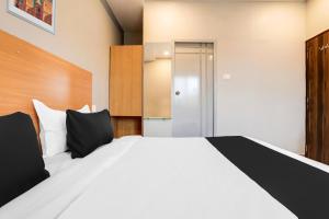 a bedroom with a large white bed with black pillows at Super Collection O RBS ECIL in Hyderabad