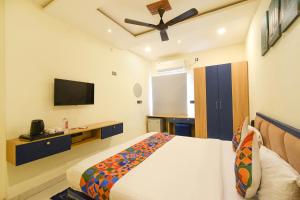 a bedroom with a bed and a flat screen tv at FabHotel Lake View Castle in Warangal