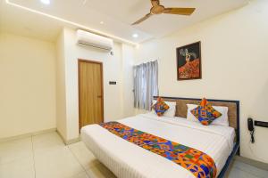 a bedroom with a large bed with a ceiling at FabHotel Lake View Castle in Warangal