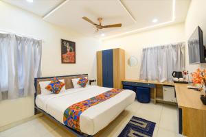 a bedroom with a bed and a desk in it at FabHotel Lake View Castle in Warangal