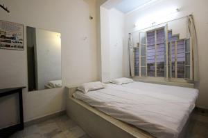 a bed in a room with a mirror and a window at Lalghat Haveli in Udaipur +19 photos