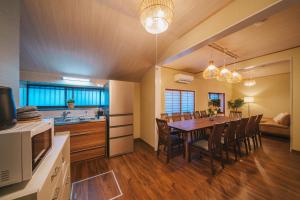 a kitchen and dining room with a table and chairs at アリュール照波園 in Beppu