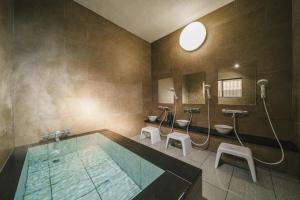 a bathroom with a swimming pool and two sinks at アリュール照波園 in Beppu