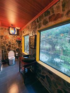 a stone bathroom with a sink and a window at Trang An Mountain River Ecolodge in Ninh Binh