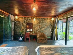 a room with two beds and a stone wall at Trang An Mountain River Ecolodge in Ninh Binh