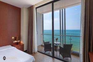 a hotel room with a bed and a view of the ocean at Amarin Resort & Spa Phu Quoc in Phú Quốc
