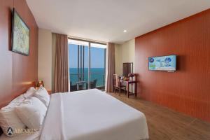 a hotel room with a bed and a large window at Amarin Resort & Spa Phu Quoc in Phú Quốc