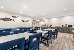 a dining room with tables and blue chairs at La Quinta by Wyndham Newport in Newport