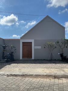 a white building with motorcycles parked in front of it at Naung CoLiving in Kerobokan