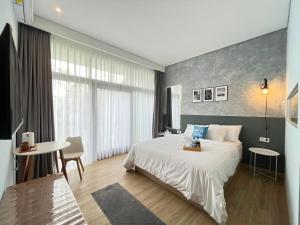 a bedroom with a large bed and a table at Turuku in Bandung +10 photos