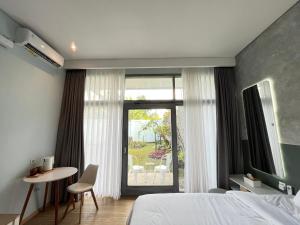 a bedroom with a bed and a table and a window at Turuku in Bandung