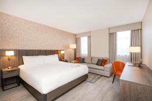 a hotel room with a large bed and a couch at Hyatt House Aparthotel Leeds in Leeds
