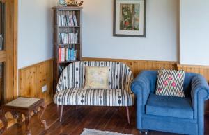 a living room with a couch and a chair at amã Stays & Trails Eagle's Nest, Gangtok, Sikkim in Bhurtuk