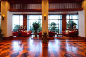 a lobby with red couches and tables and windows at Wienglakor Hotel Lampang in Lampang