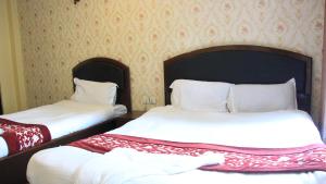 a bedroom with two beds with white sheets at Bhuwani Himalayan Height Hotel in Kathmandu
