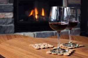 a glass of wine and two wine glasses on a table at Lakefront - Chalet Le Missionnaire in Trois Rives +15 photos