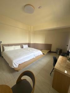 a bedroom with a bed and a desk and chairs at Royal Court B&B in Donggang +13 photos