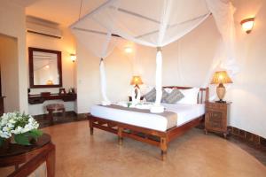 a bedroom with a bed with a canopy at Ocean Paradise Resort & Spa in Pwani Mchangani