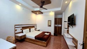 a bedroom with a bed and a flat screen tv at MIST RESIDENCY in Kattappana