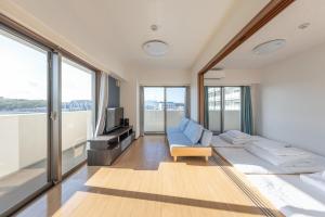 a living room with a couch and a tv at Jintai House601 in Shiobaru