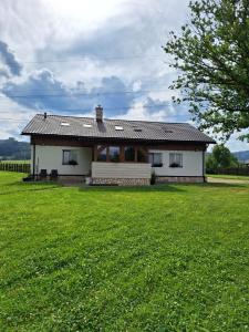a small house in a field with a green yard at Vila pod Dubem in Návsí u Jablunkova