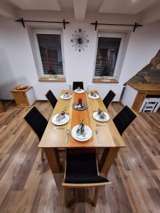 a dining room with a wooden table and chairs at Vila pod Dubem in Návsí u Jablunkova
