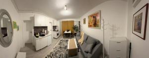 a living room with a couch and a kitchen at Boheme Studio in Timişoara