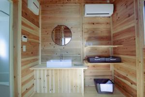 a bathroom with a sink in a wooden wall at Shinon 森音 in Tateyama +140 photos
