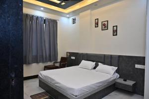 a bedroom with a large bed with white sheets at Hotel Radhe in Bhind