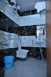 a bathroom with a toilet and a sink at Hotel Radhe in Bhind