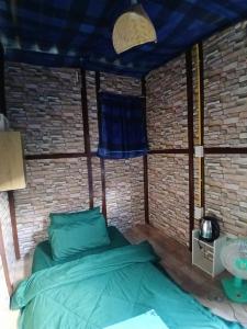 a bed in a room with a brick wall at Kalaland in Patong Beach +2 photos