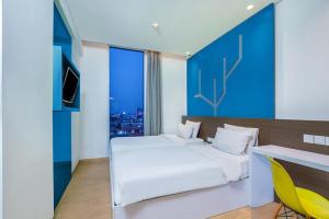 a bedroom with a white bed and a yellow chair at Asyana Pemuda Jakarta in Jakarta +19 photos