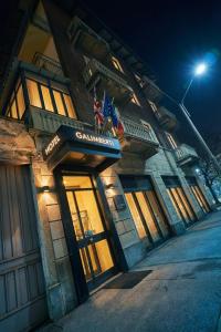 a building with a sign on the front of it at night at Hotel Galimberti in Turin